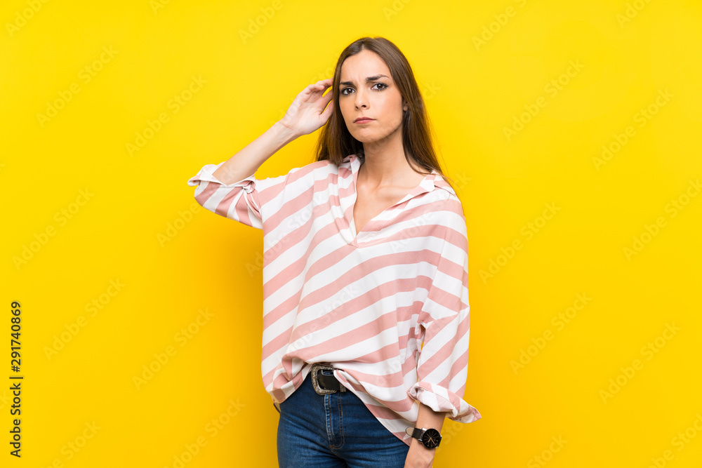 Young woman over isolated yellow background having doubts Young woman over isolated yellow background having doubts