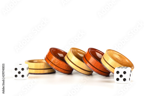 Dice and wooden backgammon checkers isolated on a white background.