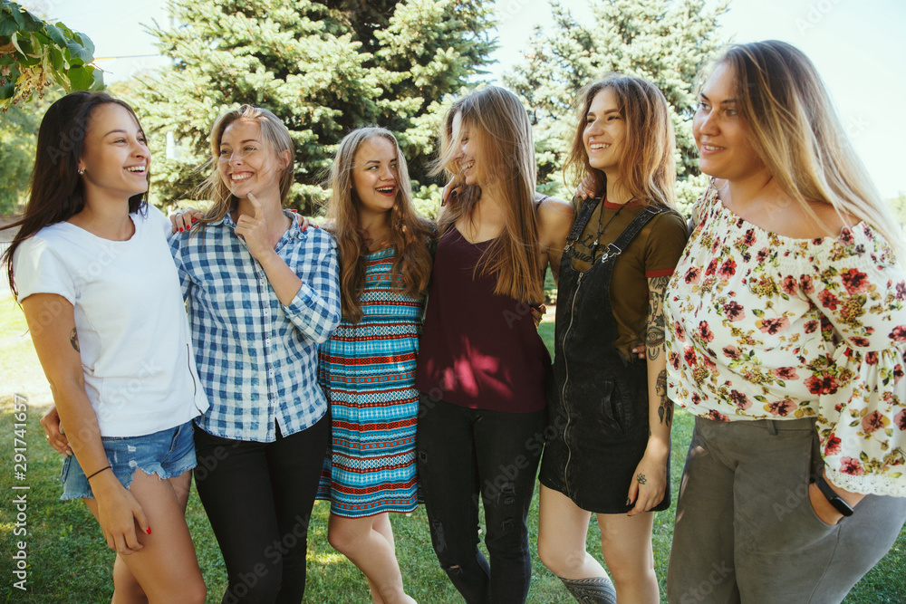 Different and happy in their bodies. Young women smiling, talking, walking and having fun together outdoors on sunny summer's day at park. Girl power, feminism, women's rights, friendship concept. Different and happy in their bodies. Young women smiling, talking, walking and having fun together outdoors on sunny summer's day at park. Girl power, feminism, women's rights, friendship concept.