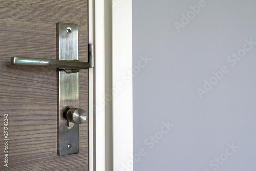 Brown door with stainless steel handles, unlocking the entrance. © leaw197340