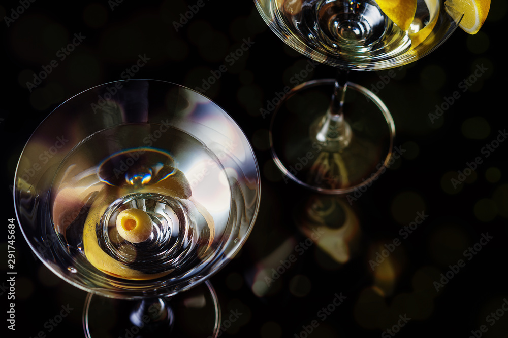 Martini Glasses with olive and lemon piece  on a black background. Selective focus. Close up.
