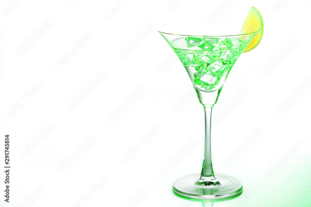Green Martini glasses with piece of lemon and ice on white background. Close up. Selective focus. Green Martini glasses with piece of lemon and ice on white background. Close up. Selective focus.