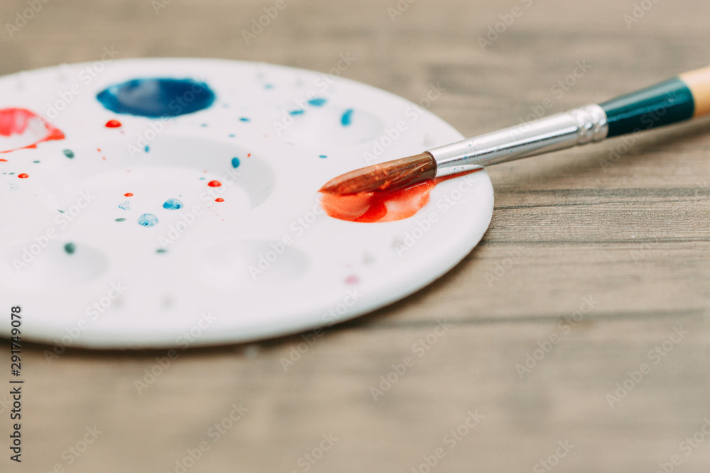 Water color and mixed colour plate and paint brush put on the wood table for draw art to paper. Water color and mixed colour plate and paint brush put on the wood table for draw art to paper.
