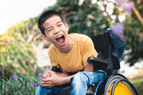 Disabled child on wheelchair is playing, learning and exercise in the outdoor city park like other people,Lifestyle of special child,Life in the education age of children,Happy disability kid concept. photo