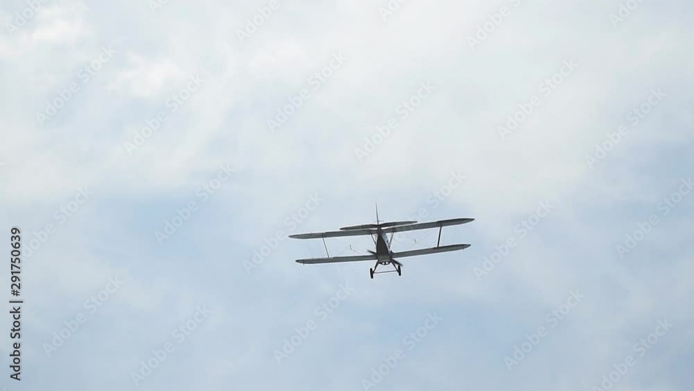 Ancient Russian aircraft biplane An2 flying in the blue sky. Slow motion Ancient Russian aircraft biplane An2 flying in the blue sky. Slow motion