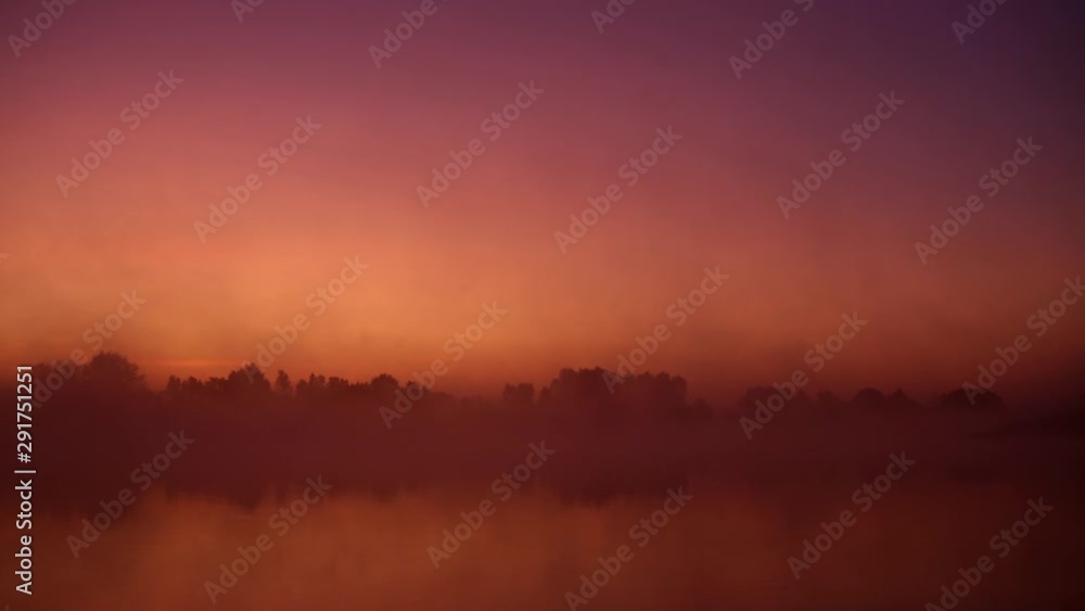 Mist over the river. Dusk over the lake. Very dense fog. Dawn in morning. Red sky over the water. The morning comes. Forest reflected on water surface. Misty morning sky. Gothic background Mist over the river. Dusk over the lake. Very dense fog. Dawn in morning. Red sky over the water. The morning comes. Forest reflected on water surface. Misty morning sky. Gothic background