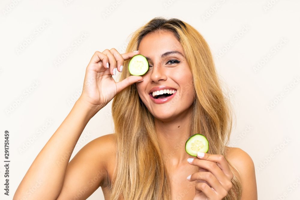 Young blonde woman holding slices of cucumber Young blonde woman holding slices of cucumber