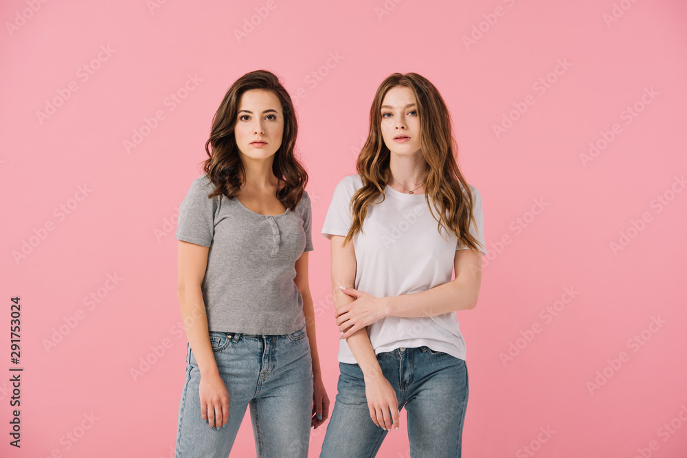 attractive women in t-shirts looking at camera isolated on pink attractive women in t-shirts looking at camera isolated on pink