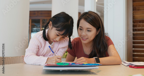 Fotografie Tutor teaches girl to draw on the book