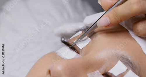 Asian woman with eyelash extension in beauty salon