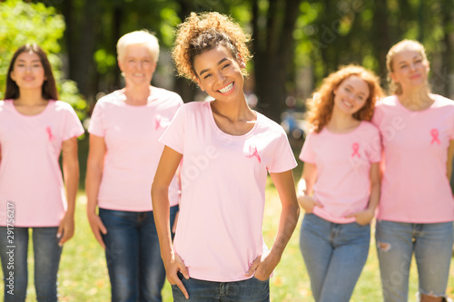 Breast Cancer Volunteer Standing In Front Diverse Ladies In Park
