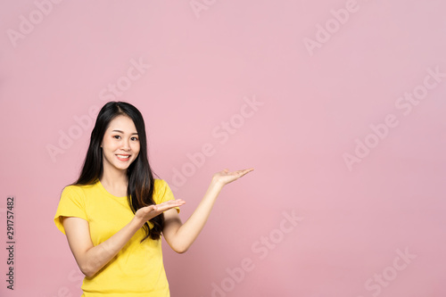 Portrait of Asian beautiful young woman presenting with two hand on upper left side with smile face. The girl standing and looking at camera in studio. Advertisement   presentation concept.