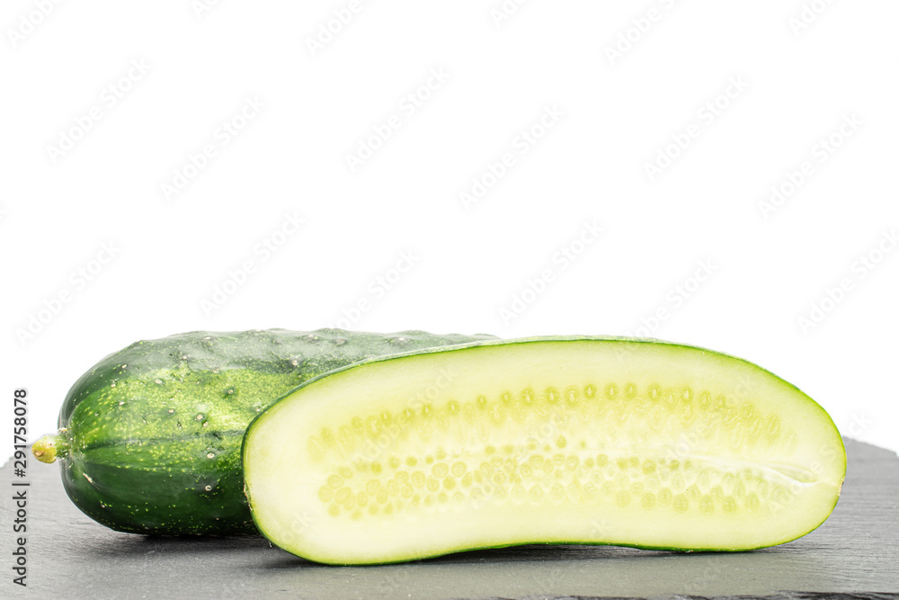 Group of one whole two halves of fresh green pickling cucumber on grey stone isolated on white background Group of one whole two halves of fresh green pickling cucumber on grey stone isolated on white background