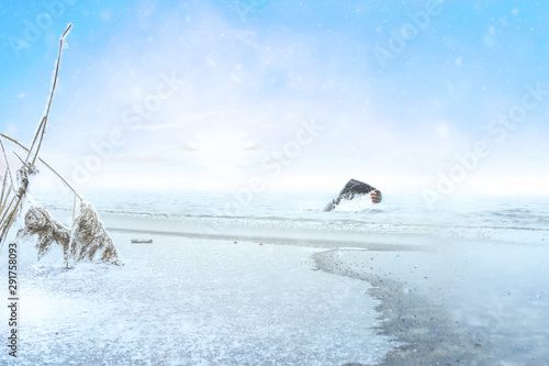 Fototapeta Naklejka Na Ścianę i Meble -  Extreme athlete swimming in winter in a frozen lake
