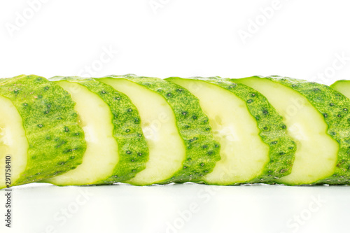 Lot of slices of fresh green pickling cucumber in line isolated on white background photo