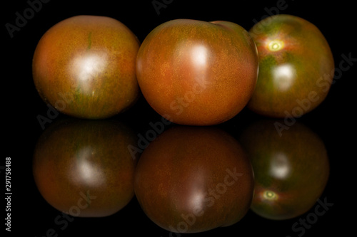 Group of three whole fresh green red tomato isolated on black glass