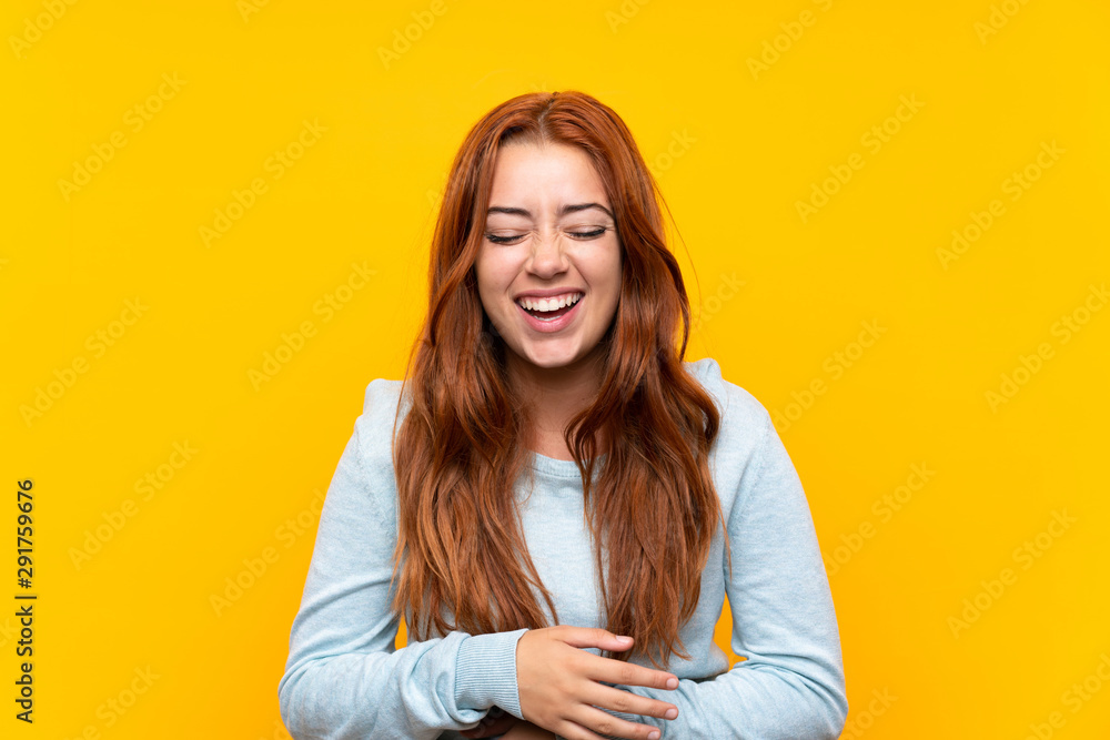 Teenager redhead girl over isolated yellow background smiling a lot - obrazy, fototapety, plakaty 