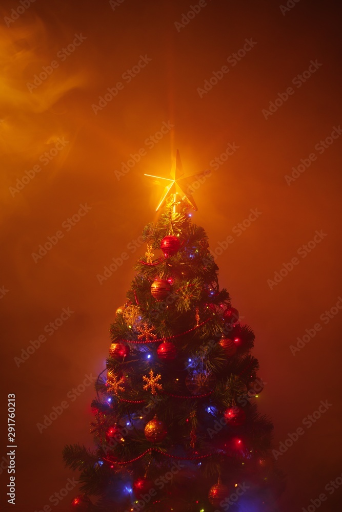 Christmas tree with festive lights, orange background with smoke Christmas tree with festive lights, orange background with smoke
