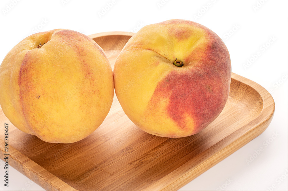 Group of three whole fresh fuzzy peach on bamboo plate isolated on white background Group of three whole fresh fuzzy peach on bamboo plate isolated on white background