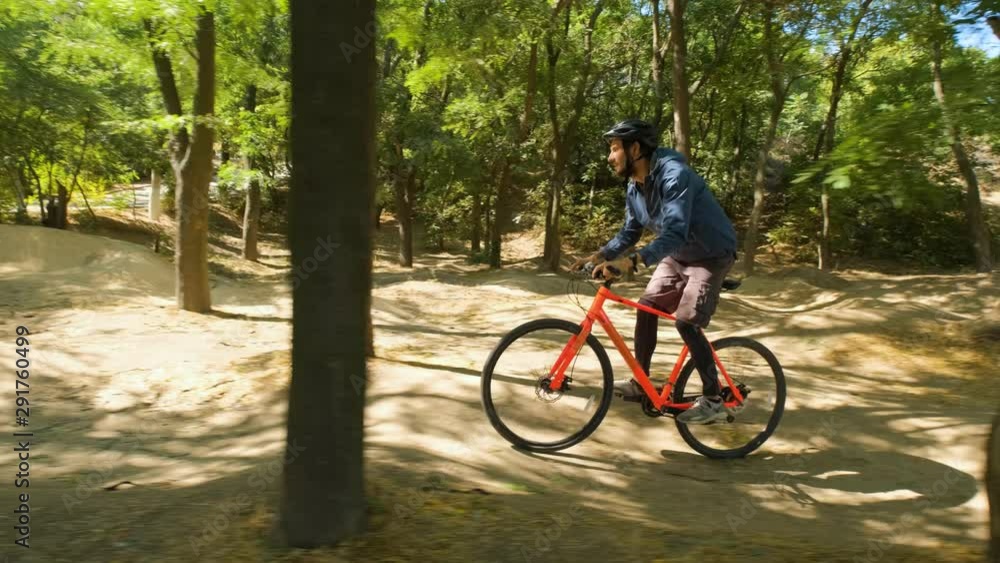 Young male on the bicycle with helmet ride in the forest in sunny day 4K UHD Young male on the bicycle with helmet ride in the forest in sunny day 4K UHD