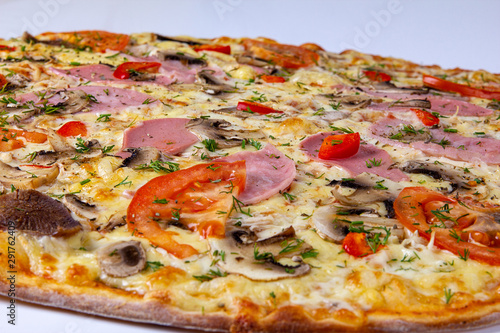Pizza closeup background with ham, beef and tomatoes
