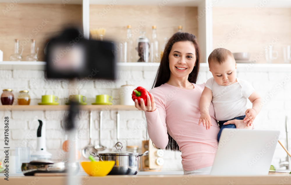 Young mother with little son shooting video about baby nutrition