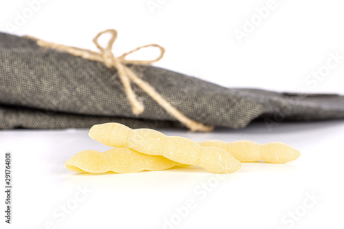 Group of three whole uncooked pasta cavatelli with grey textil napkin isolated on white background photo