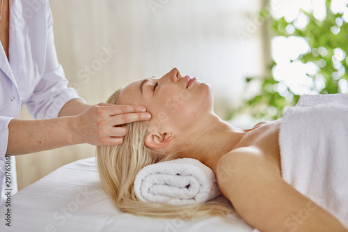 Beautiful woman with closed eyes getting a massage in the spa s