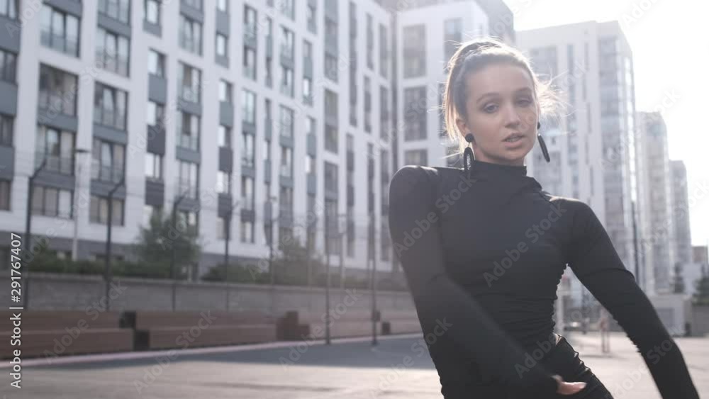 Woman dancing and enjoying modern Vogue dance on the street on sunny day. Contemporary dance. Enjoying modern dance movement. Caucasian woman dancing outdoors. Beautiful hand movements Woman dancing and enjoying modern Vogue dance on the street on sunny day. Contemporary dance. Enjoying modern dance movement. Caucasian woman dancing outdoors. Beautiful hand movements