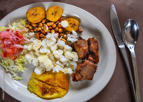 Fritada, fried pork, typical Ecuadorian dish served with hominy, sweet plantain and potato tortillas.