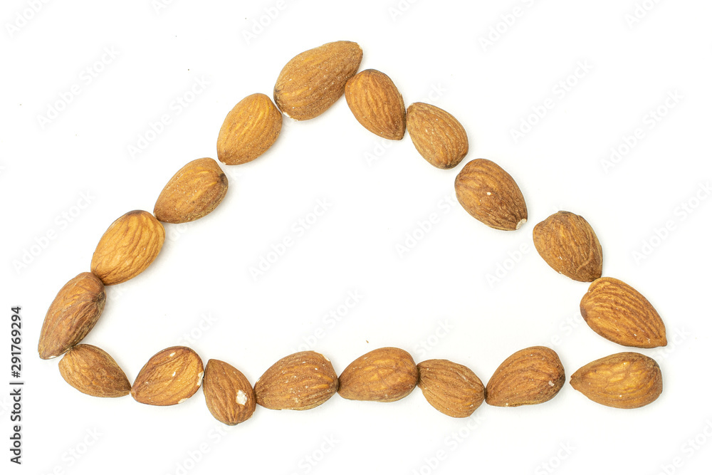 Lot of whole brown almond nut triangle flatlay on white background Lot of whole brown almond nut triangle flatlay on white background