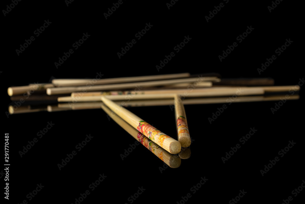 Lot of whole crossed asian brown chopsticks isolated on black glass Lot of whole crossed asian brown chopsticks isolated on black glass
