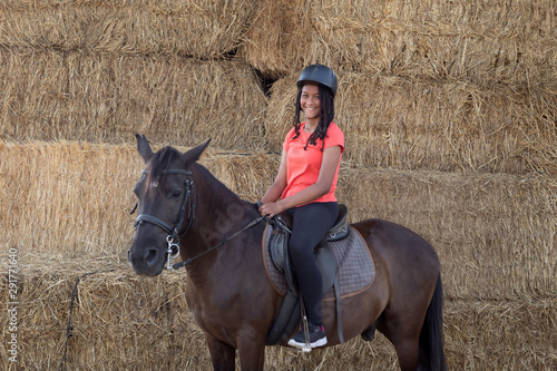 Beautiful teenager with his horse learning to ride photo