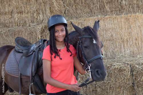 Beautiful teenager with his horse learning to ride photo