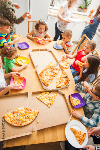 Children eating pizza in home, kids party