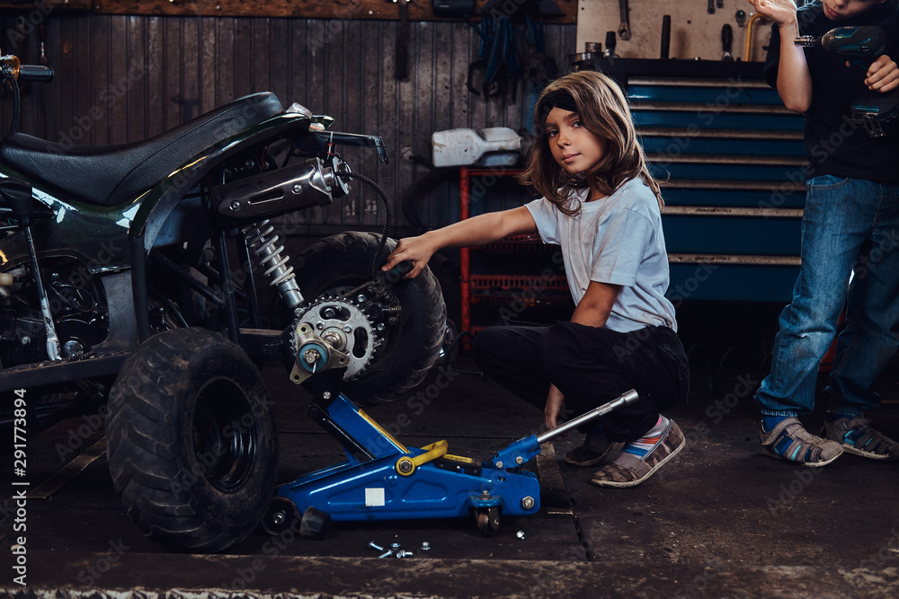 Serious beautiful girl want to be an auto technician when she grows up, she is trying to fix broken ATV. Serious beautiful girl want to be an auto technician when she grows up, she is trying to fix broken ATV.