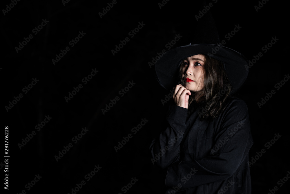 Fototapeta premium Portrait of beautiful asian woman wear witch costume on black background,Thailand people,Halloween festival concept,Horror scene