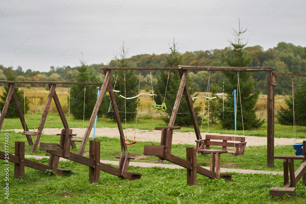 Wooden swing in the park on the street. children playground