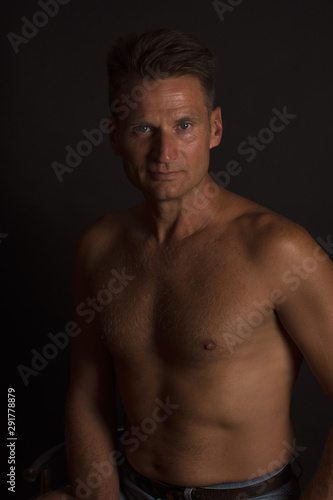 Portrait of mature man with naked bust, looking directly at camera
