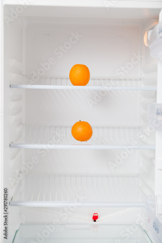 Two oranges are in empty fridge