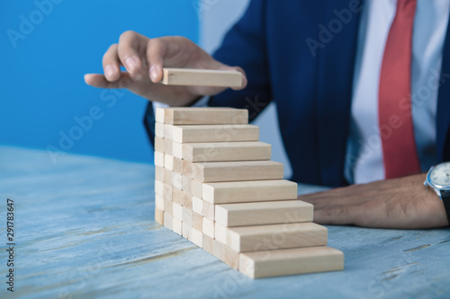 businessman stacks wooden blocks, business concept