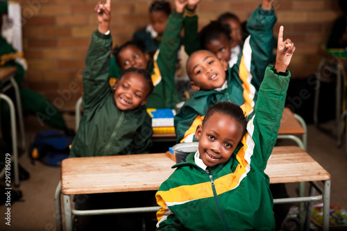 A group of school children sitting at desks with their hands up, Meyerton Primary School, Meyerton, Gauteng photo