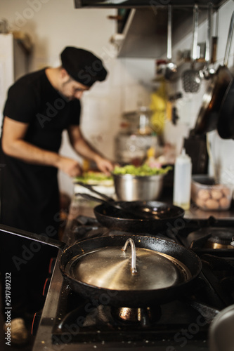 Professional chef working in restaurant kitchen and making delicious traditional food.