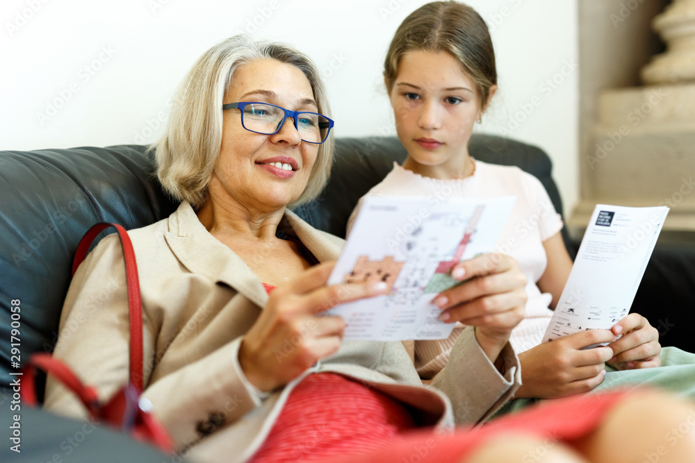 Fototapeta premium People reading guide in museum