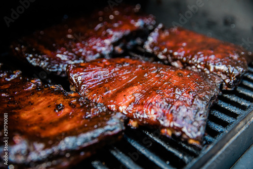 Smoked Barbecue BBQ ribs on the smoker grill charred on the edges and covered in barbecue sauce homemade photo