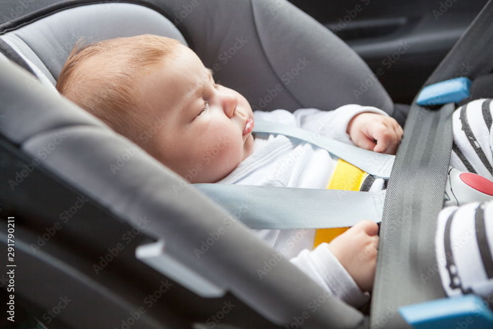Sleeping baby buckled into rear-facing car seat, close up view Sleeping baby buckled into rear-facing car seat, close up view