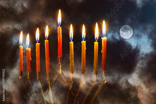 Menorah with candles for hannukah holiday celebration with full moon night sky background