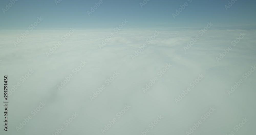 Aerial shot tilting from puffy white clouds to blue sky above the clouds, day Aerial shot tilting from puffy white clouds to blue sky above the clouds, day