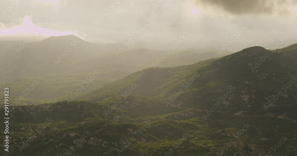 Sunlight streaming through foggy sky onto mountain tops, overcast day Sunlight streaming through foggy sky onto mountain tops, overcast day