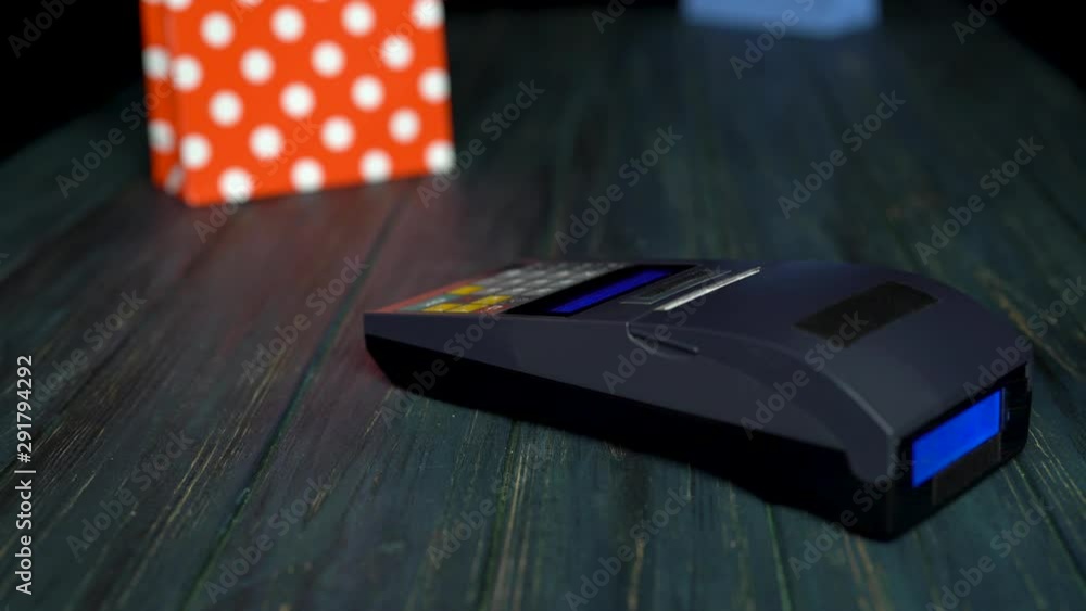 Close up of man paying in a trade with nfc system and a smartphone device wirelessly, then he takes the bag. 4k video Close up of man paying in a trade with nfc system and a smartphone device wirelessly, then he takes the bag. 4k video